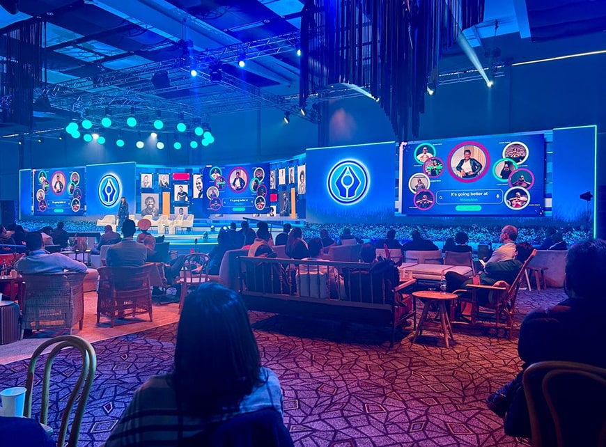 a group of people sitting in chairs in a room with a stage and lights