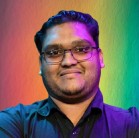 a man wearing glasses and smiling