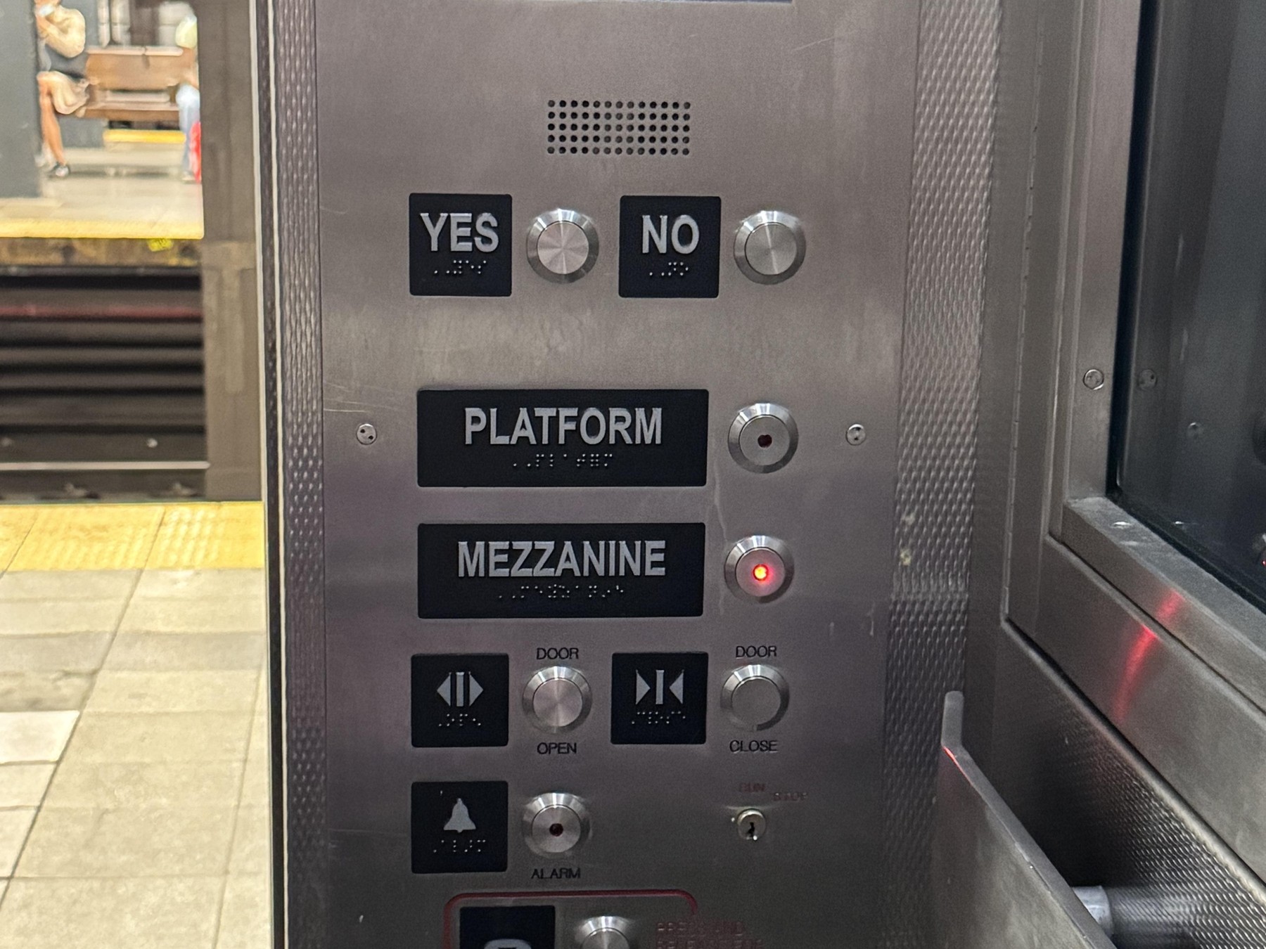 Elevator car operating panel with call buttons and the emergency phone button in an MTA subway station elevator