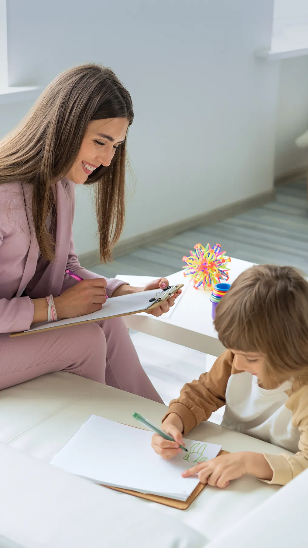 A woman sitting next to a little boy on a couch.