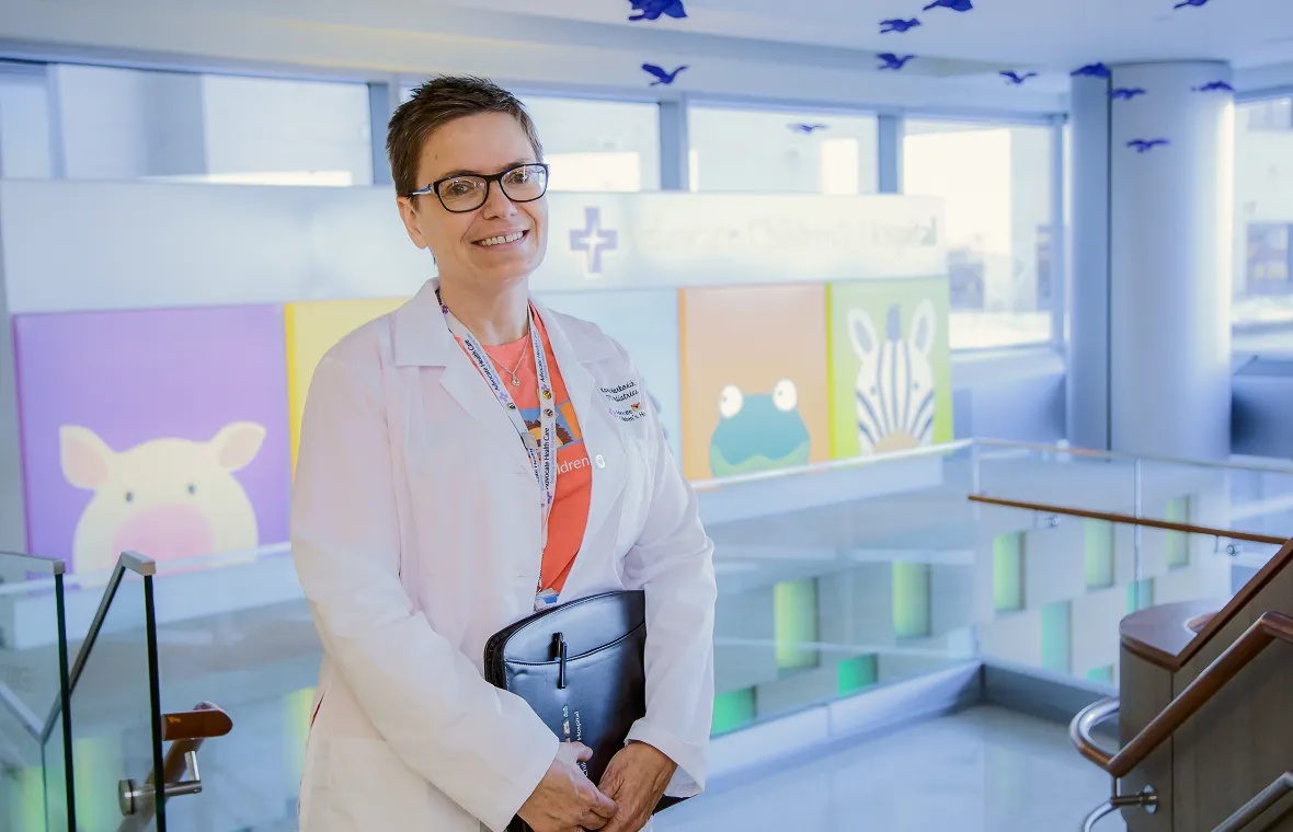A woman in a lab coat holding a folder.