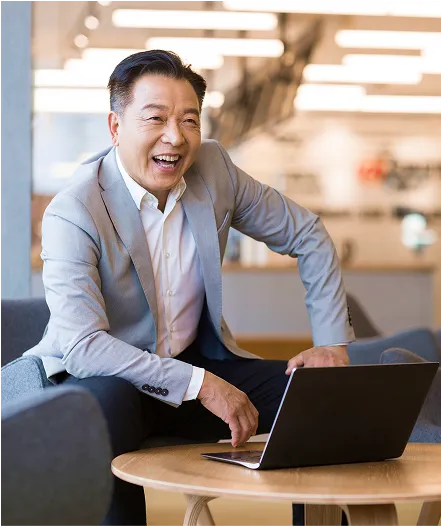 A man sitting at a table with a laptop.