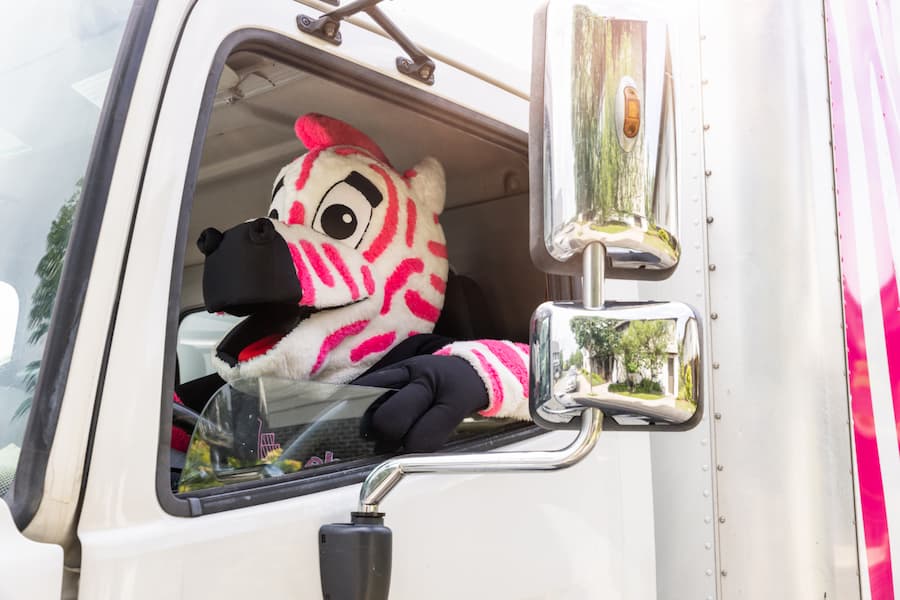 Pink Zebra mascot driving the Pink Zebra truck
