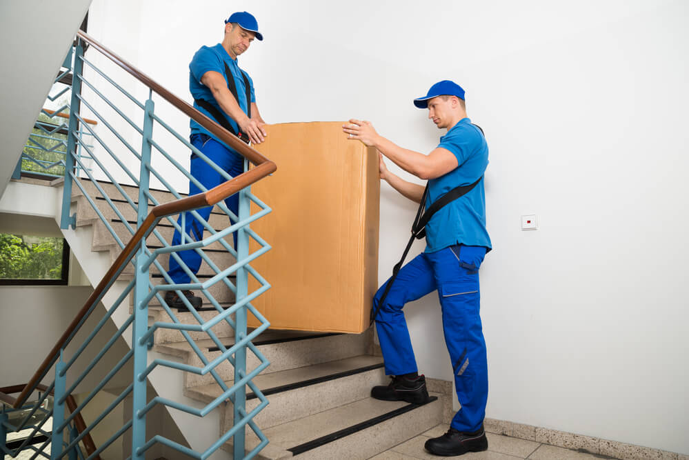 Movers in Denver carrying a box up the stairs