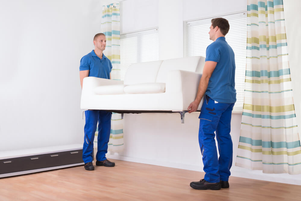 Mover in Nashville places a sofa in the living room..