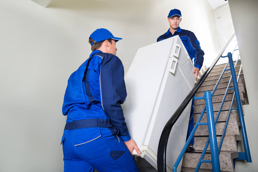 Movers in Wilmington NC carrying a fridge downstairs