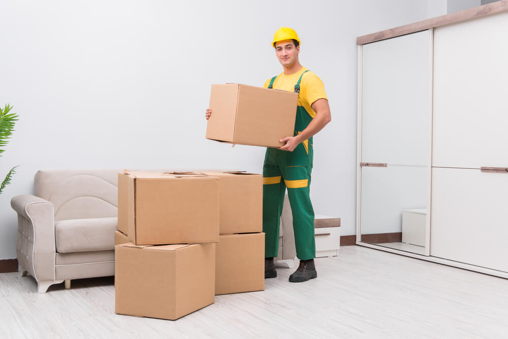Movers and packers in Charlotte NC carrying a box.