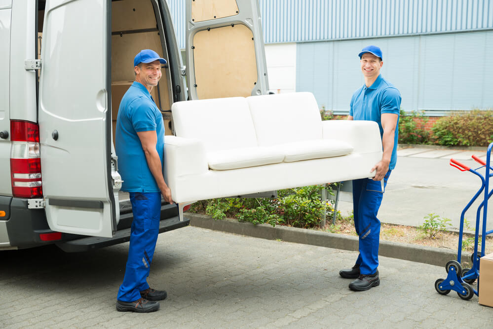 Workers from Denver Moving Companies lifting a sofa.