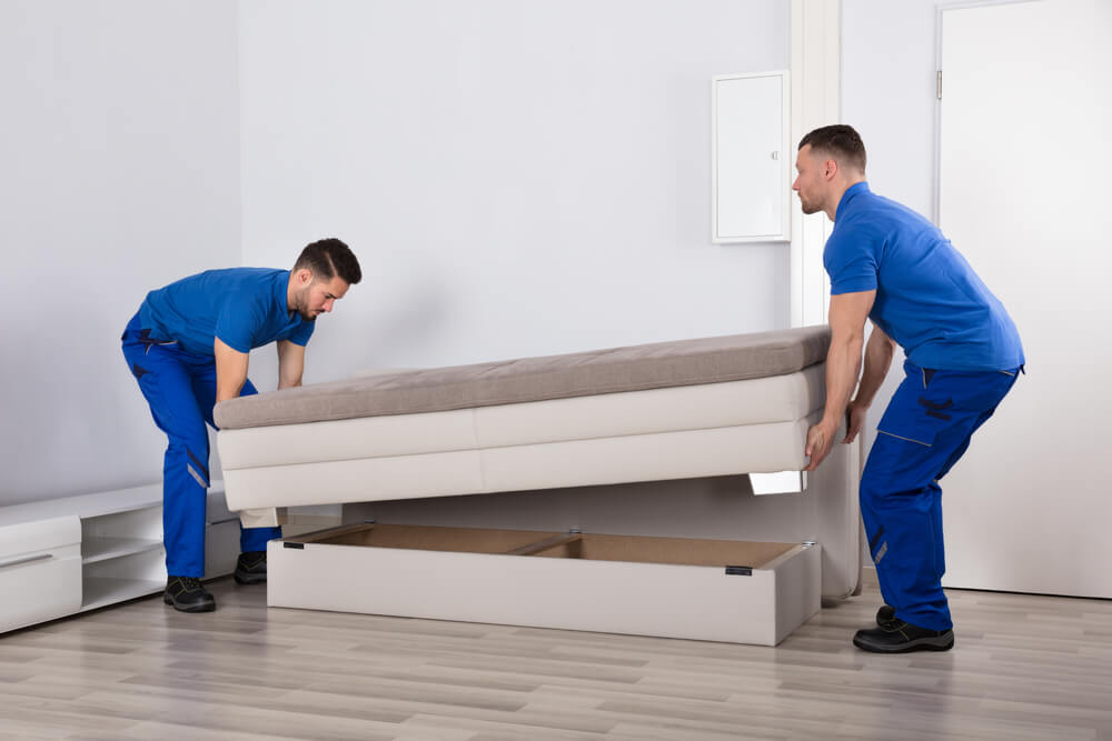 2 men lifting a couch with moving companies in Auburn AL