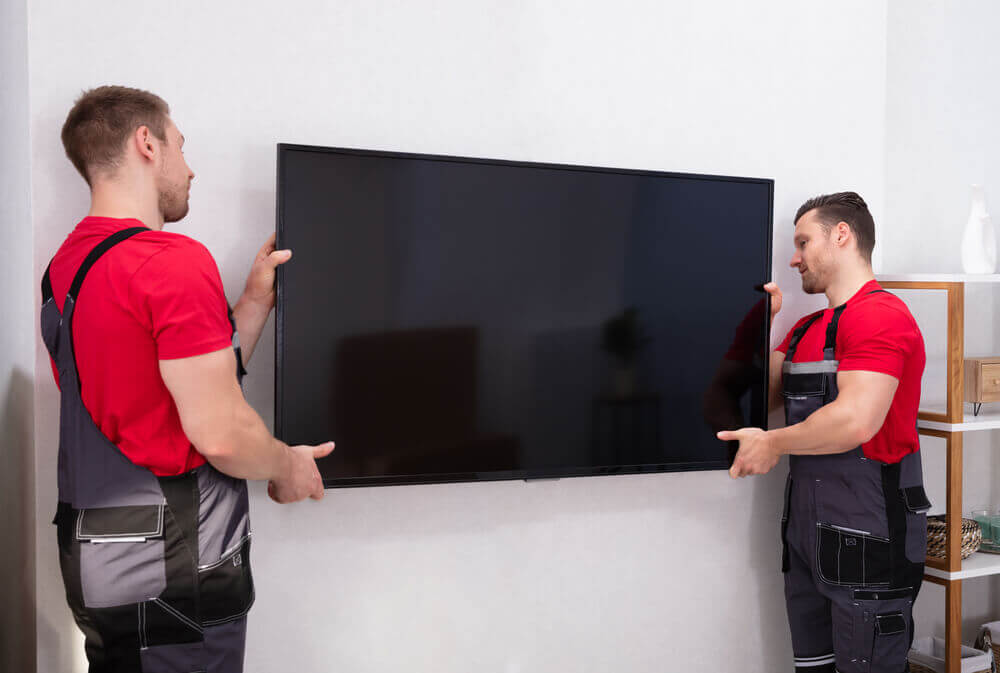 2 men removing a tv with veteran owned moving company.