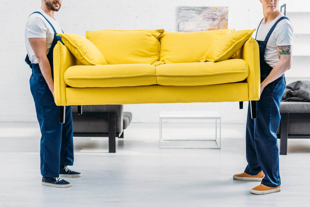 moving company in Charlotte lifting a sofa.