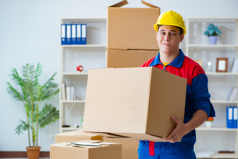 Young man working in relocation services with boxes