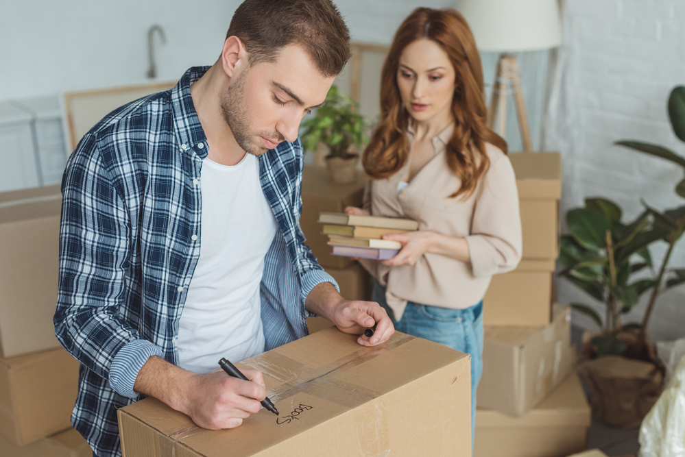 A couple labeling boxes with Athens movers.