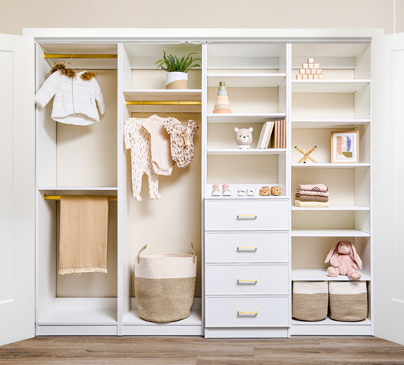 Modern walk-in closet with organized storage, featuring light wood finishes, and shelving under bright lighting.