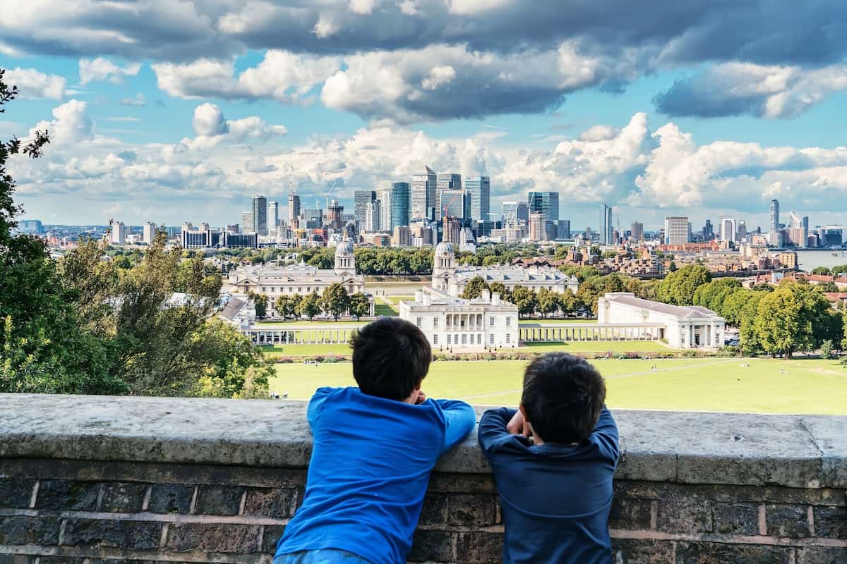 Two boys leaning on a wall looking at the London skyline