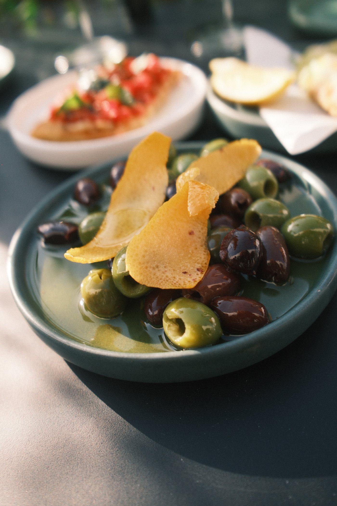 Marinated green and black olives with candied lemon peel in olive oil