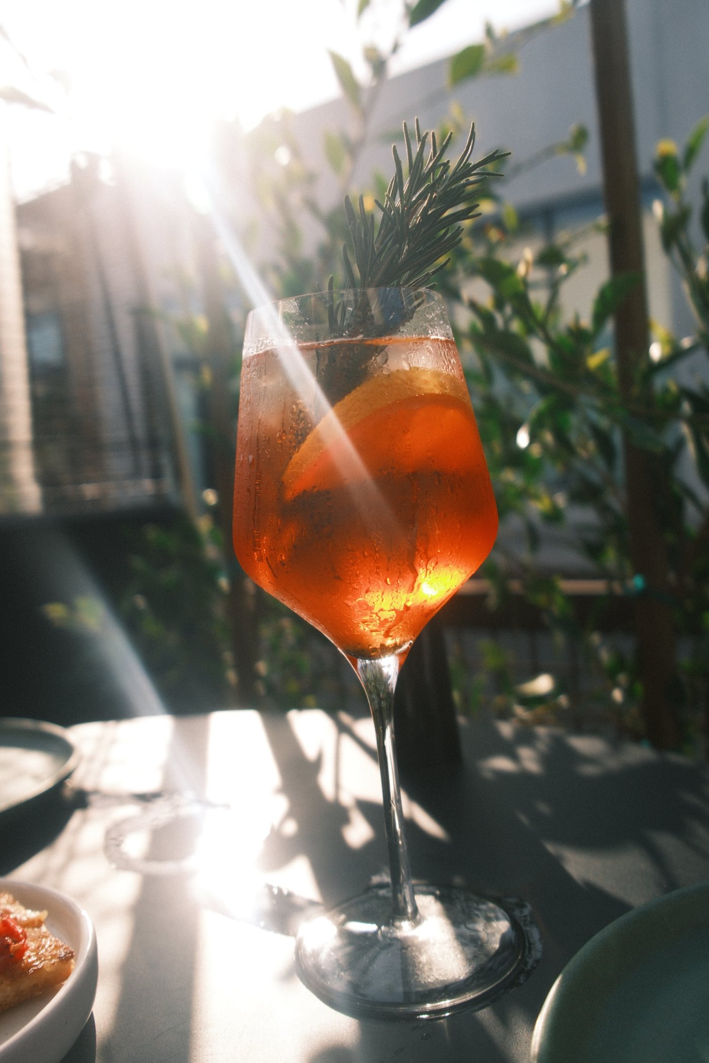 Spritz with orange and rosemary glowing in the evening sun on the Market patio