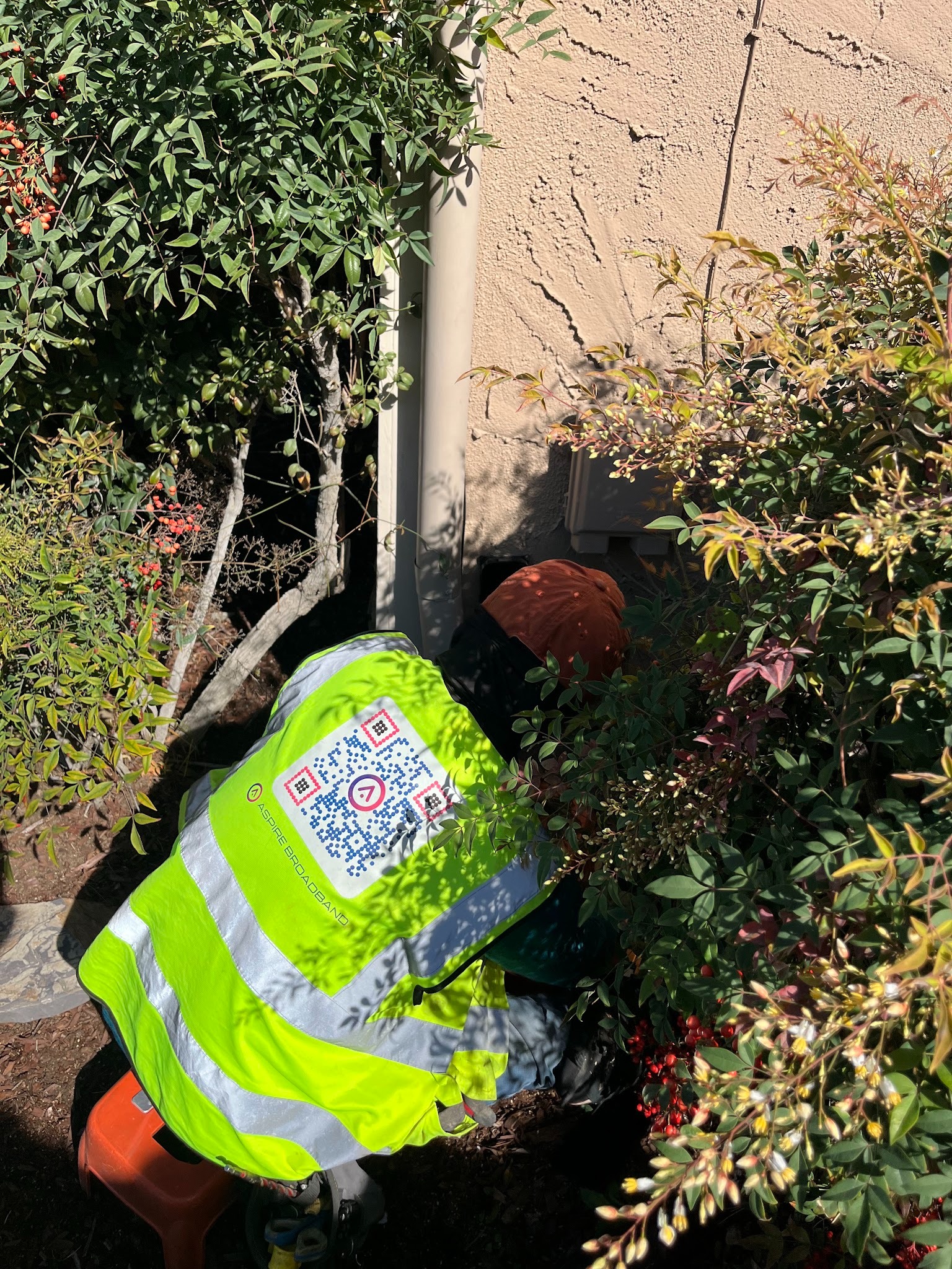 Technician installing NID box mounted on the exterior wall