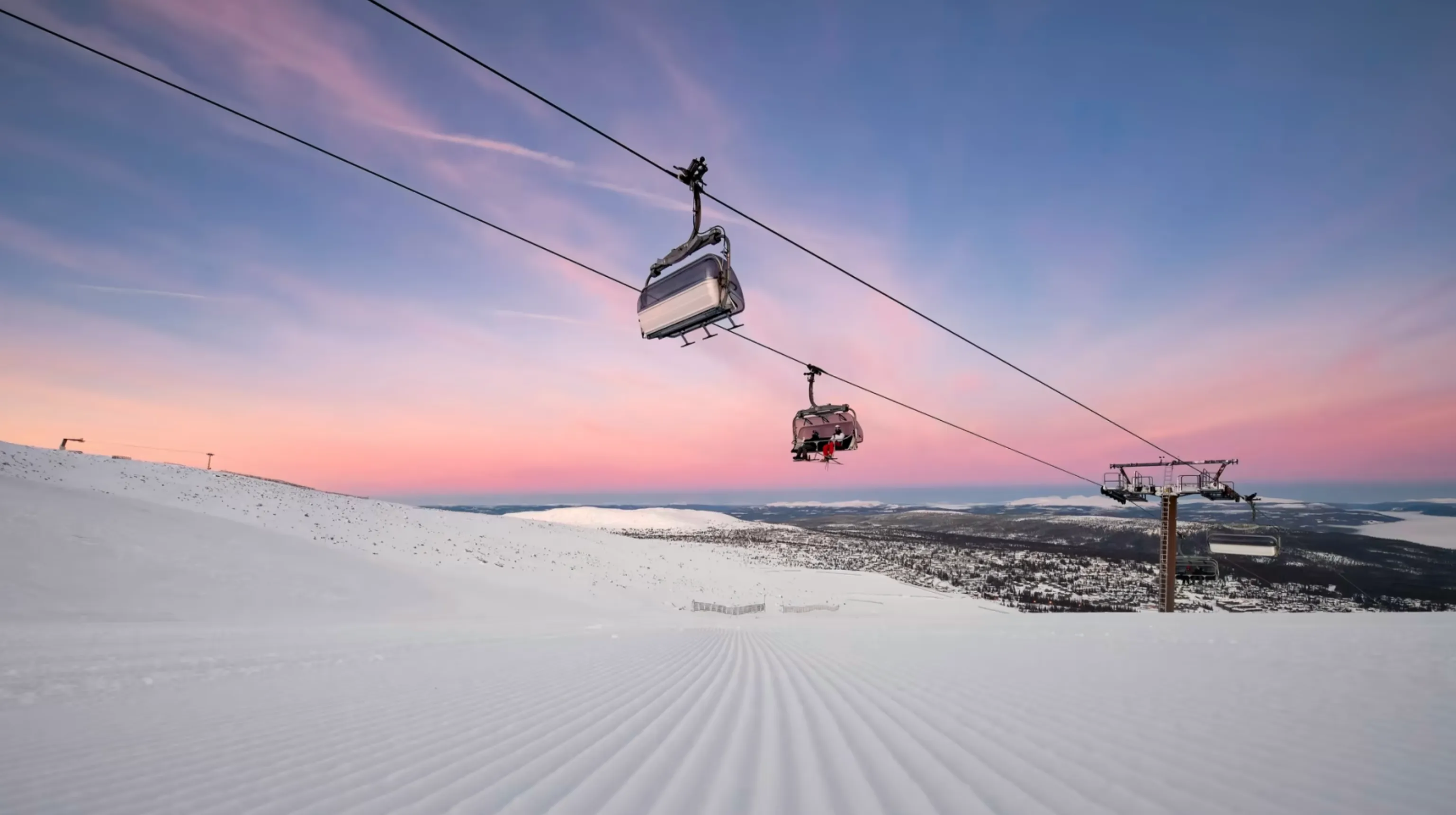 Ski lifts illuminated in the dusk light, with soft, muted colours to create a calm winter climate