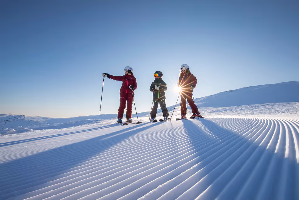 Three skiers travel across freshly plowed snow with pristine, white surfaces all around