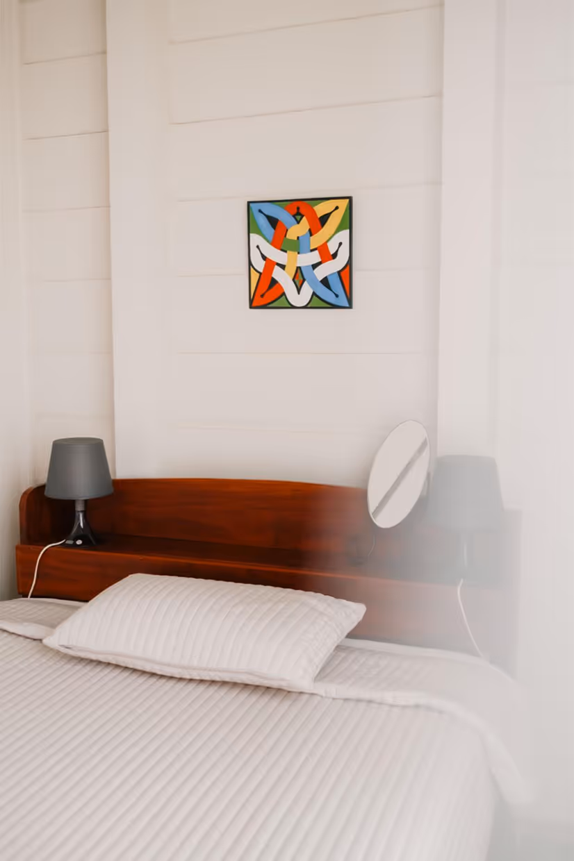 A bedroom with Surinamese art by Correa Suriname