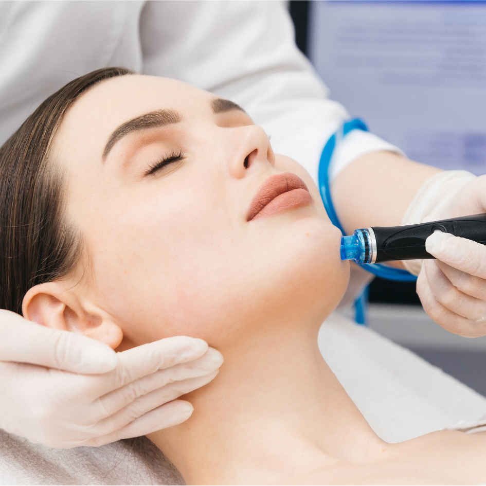 Close-up of a woman receiving a facial treatment with an orange peel applied to her cheek using a brush.