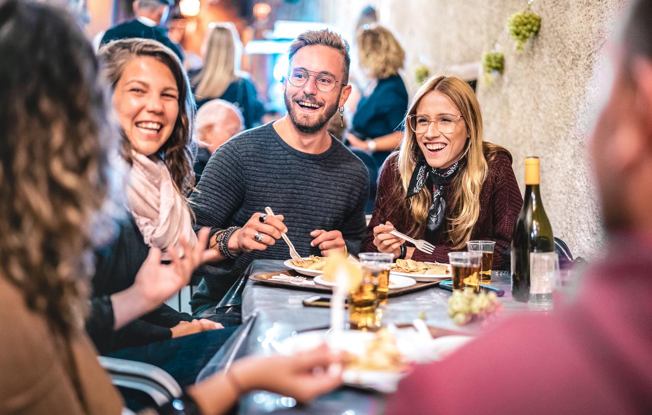 A group of 4 smiling guests at a restaurant