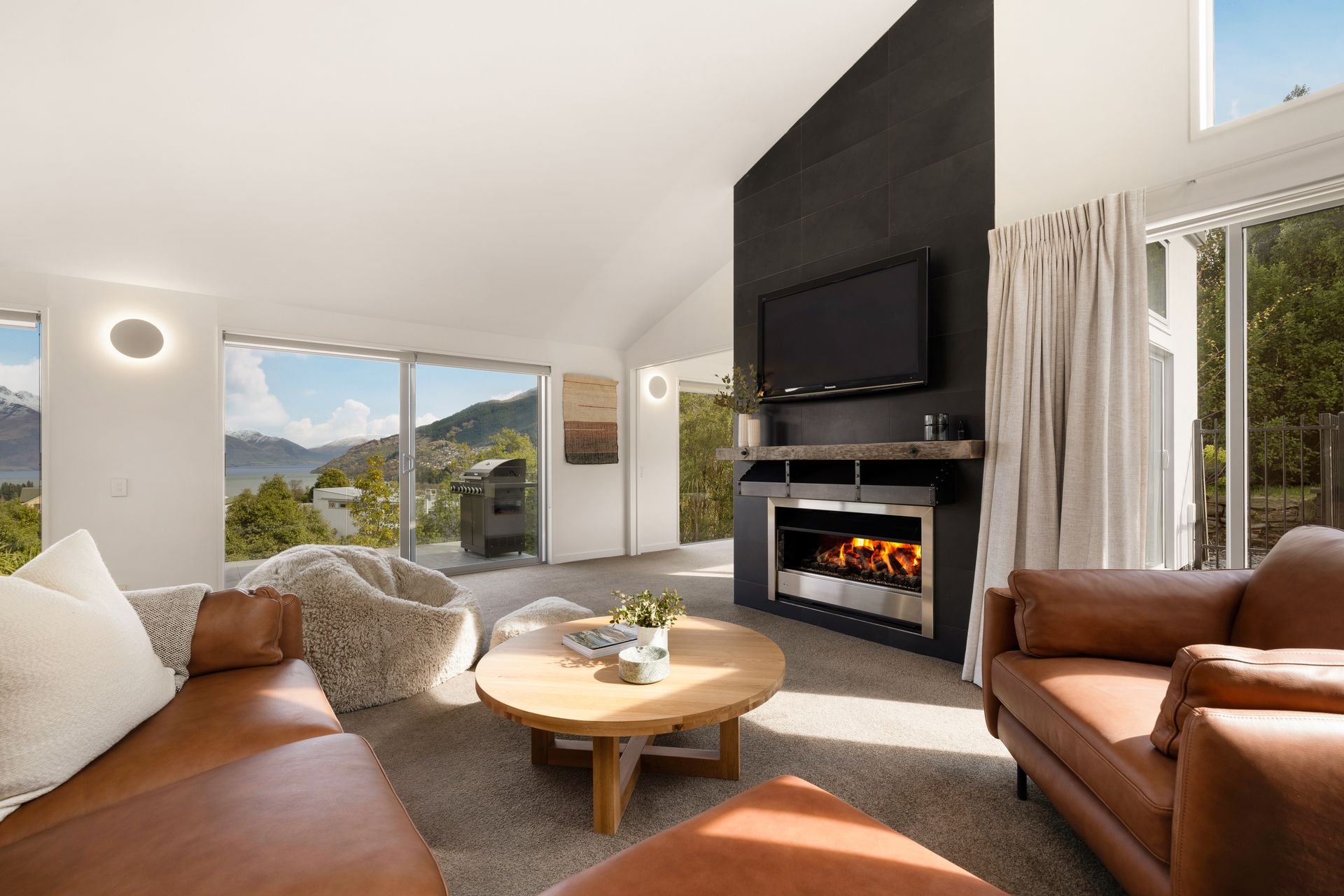 Lounge with fireplace, TV and leather sofas at Hillside Haven Queenstown