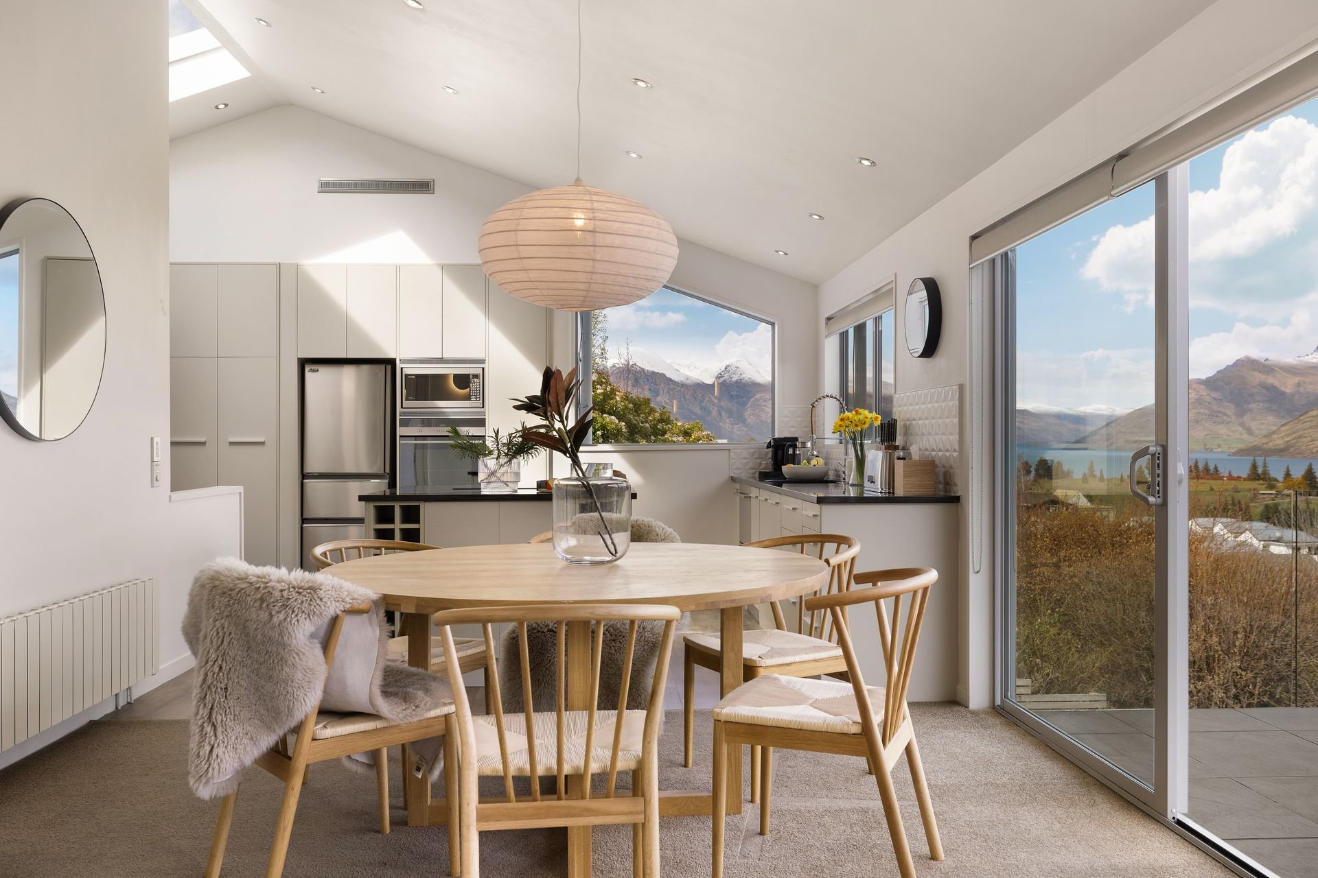 Dining table and kitchen with lake views at Hillside Haven Queenstown