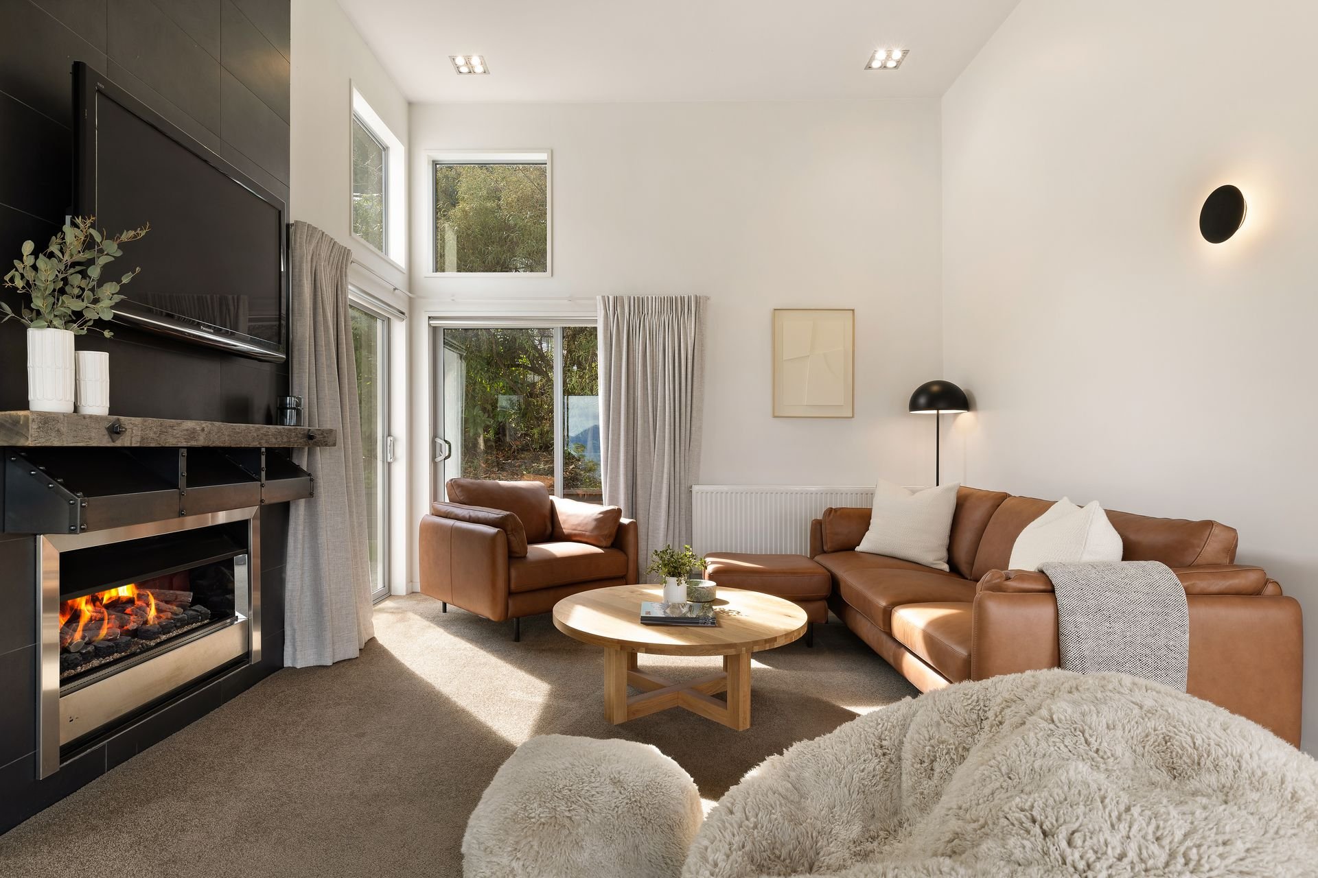Lounge with leather sofas and fireplace at Hillside Haven Queenstown