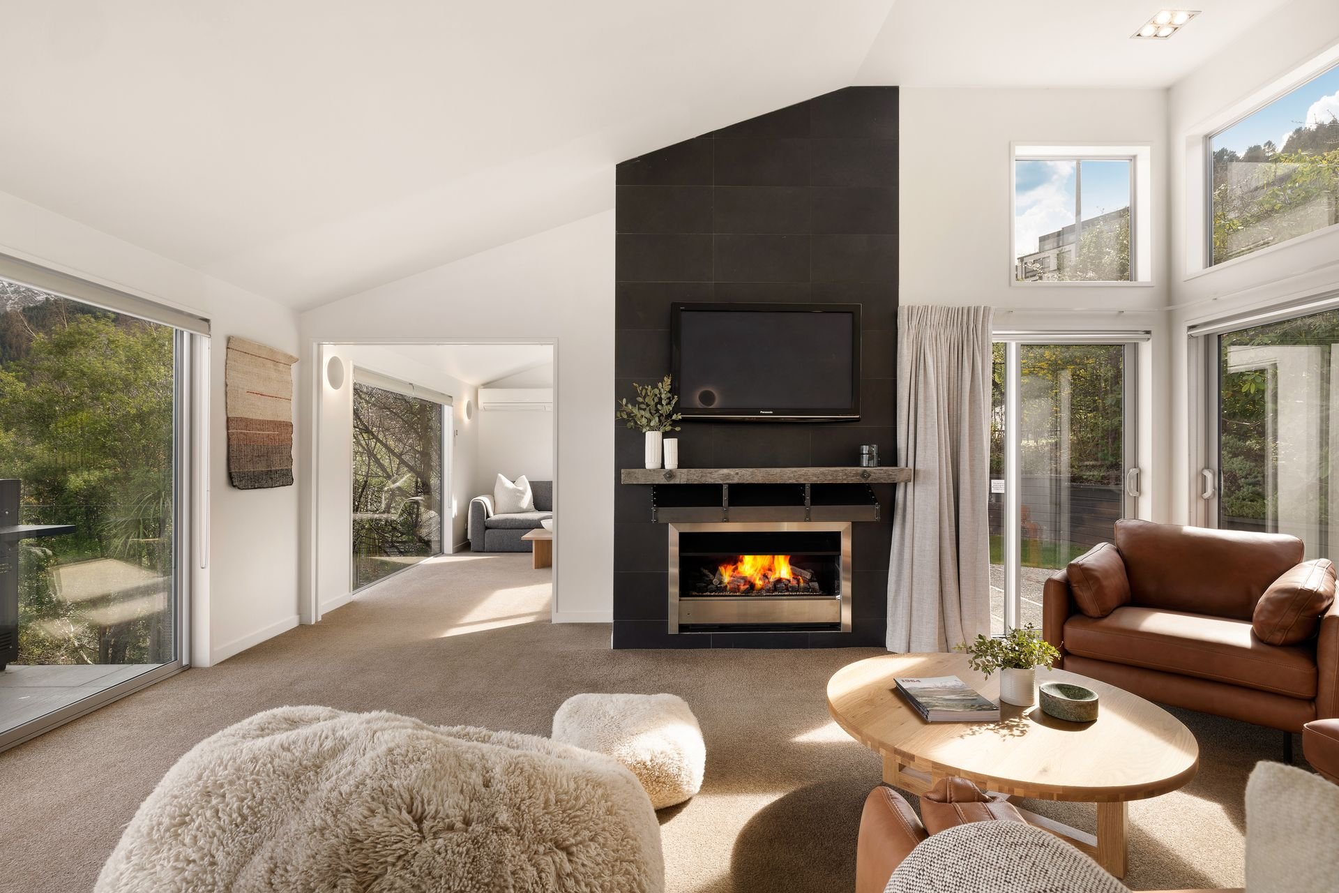 Lounge with fireplace opening onto the balcony at Hillside Haven Queenstown