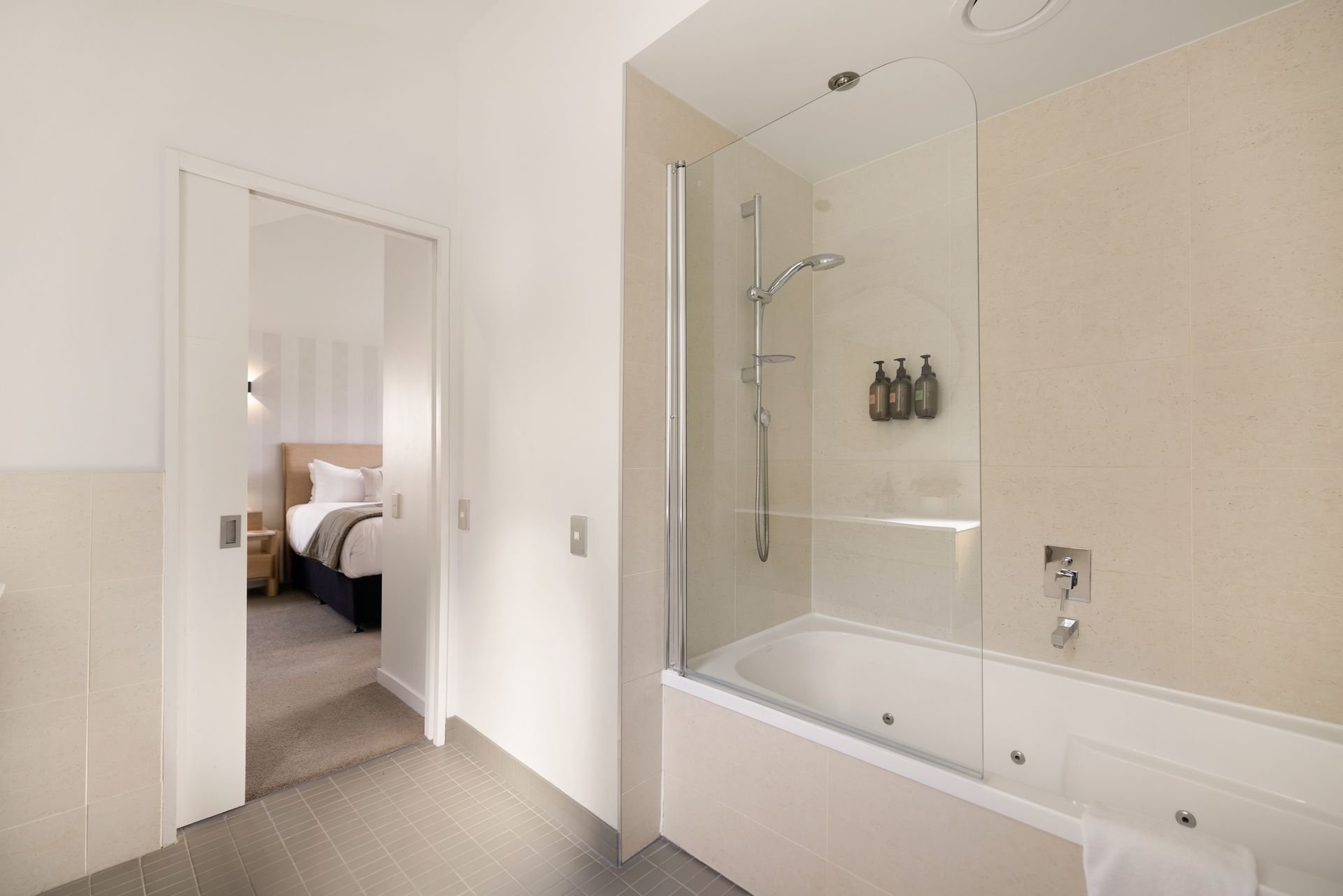 Ensuite bathroom with bath and shower at Hillside Haven Queenstown