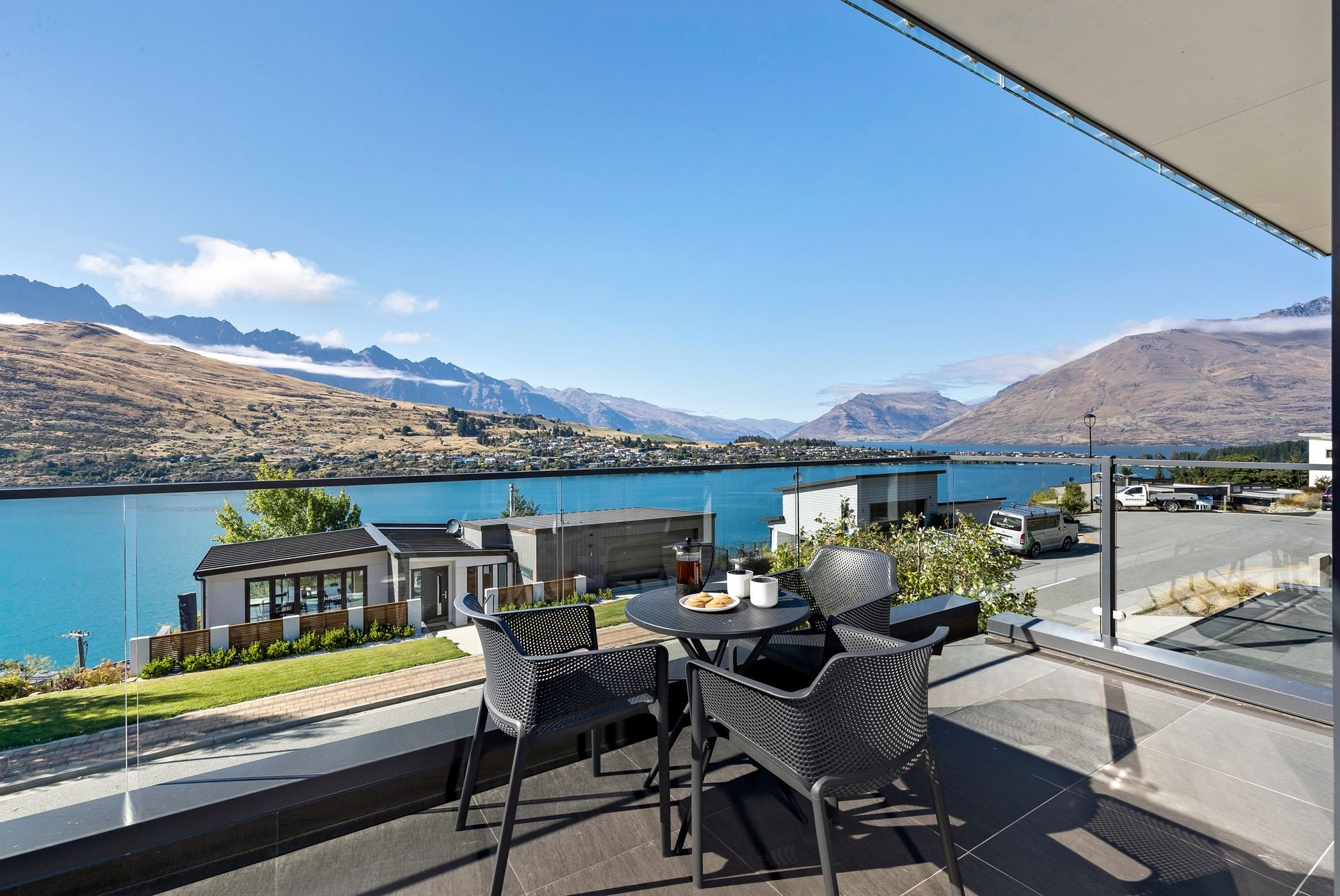 Balcony with outdoor dining table and lake views at Cecil Peak House, Queenstown