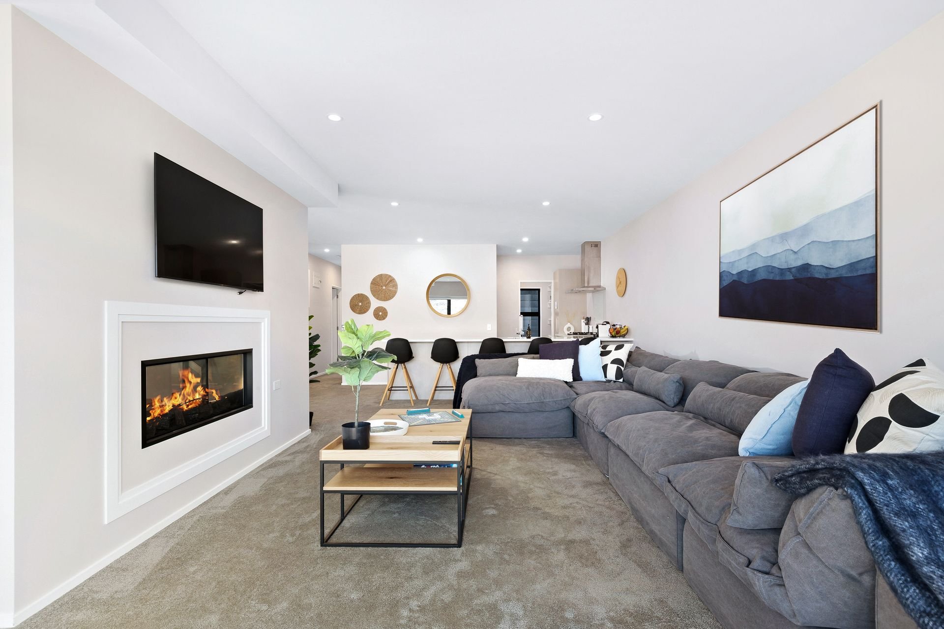 Lounge with gas fire and large sofa at Cecil Peak House, Queenstown