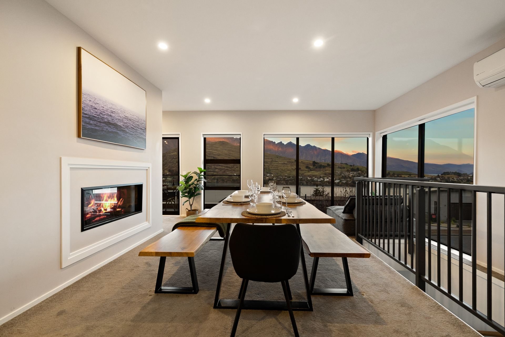 Dining table beside the gas fire with lake views at Cecil Peak House, Queenstown