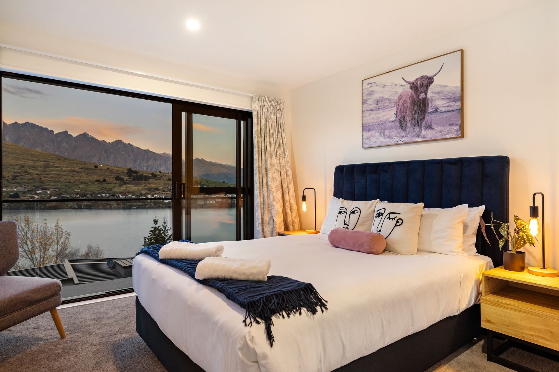 Master bedroom with lake and mountain views at Cecil Peak House, Queenstown