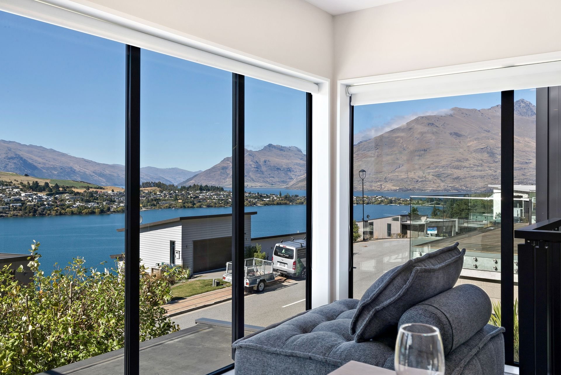 Lounge corner with floor-to-ceiling windows and lake views at Cecil Peak House, Queenstown