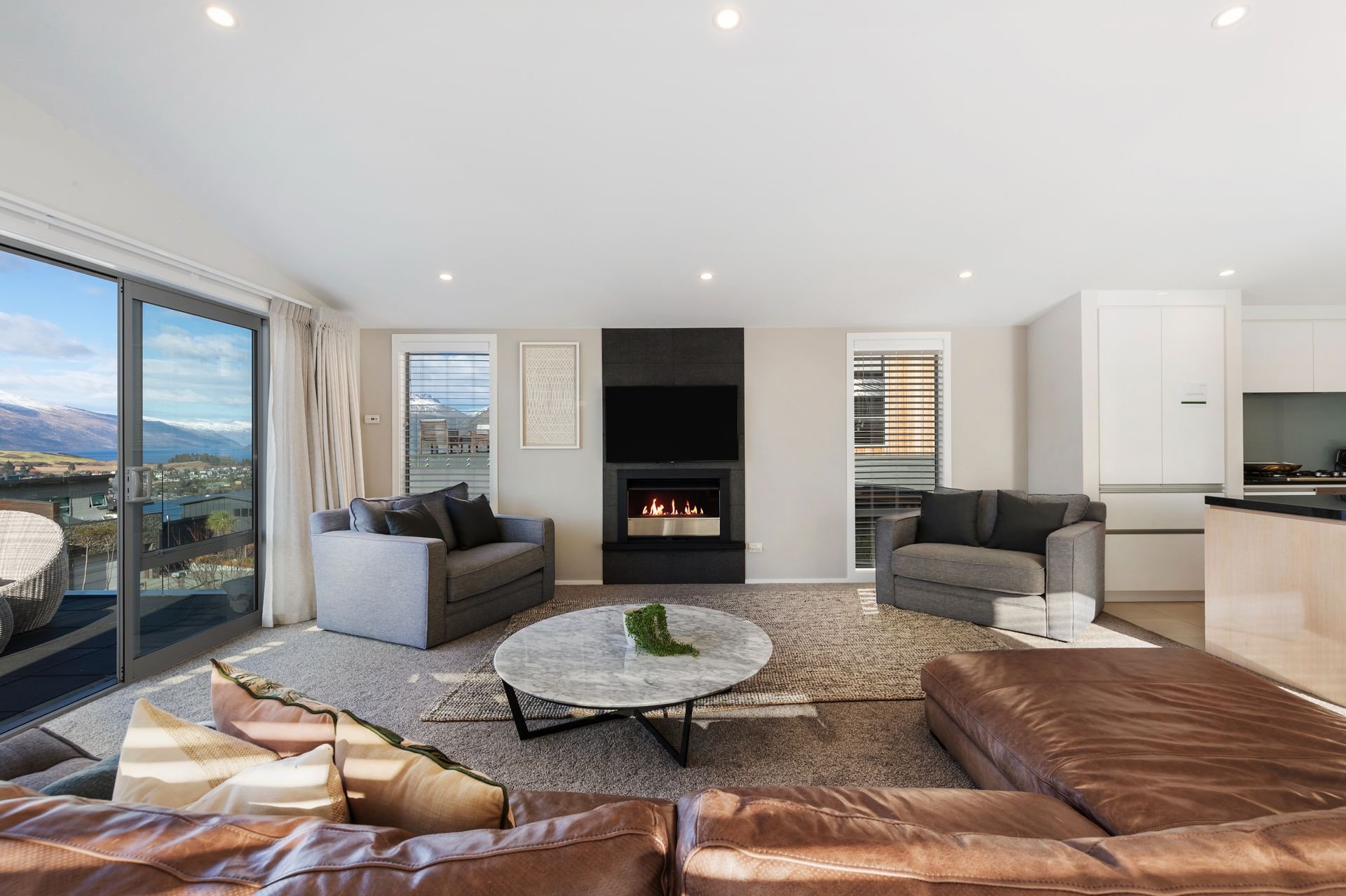 Living room with gas fire and lake views at Highview Haven, Queenstown