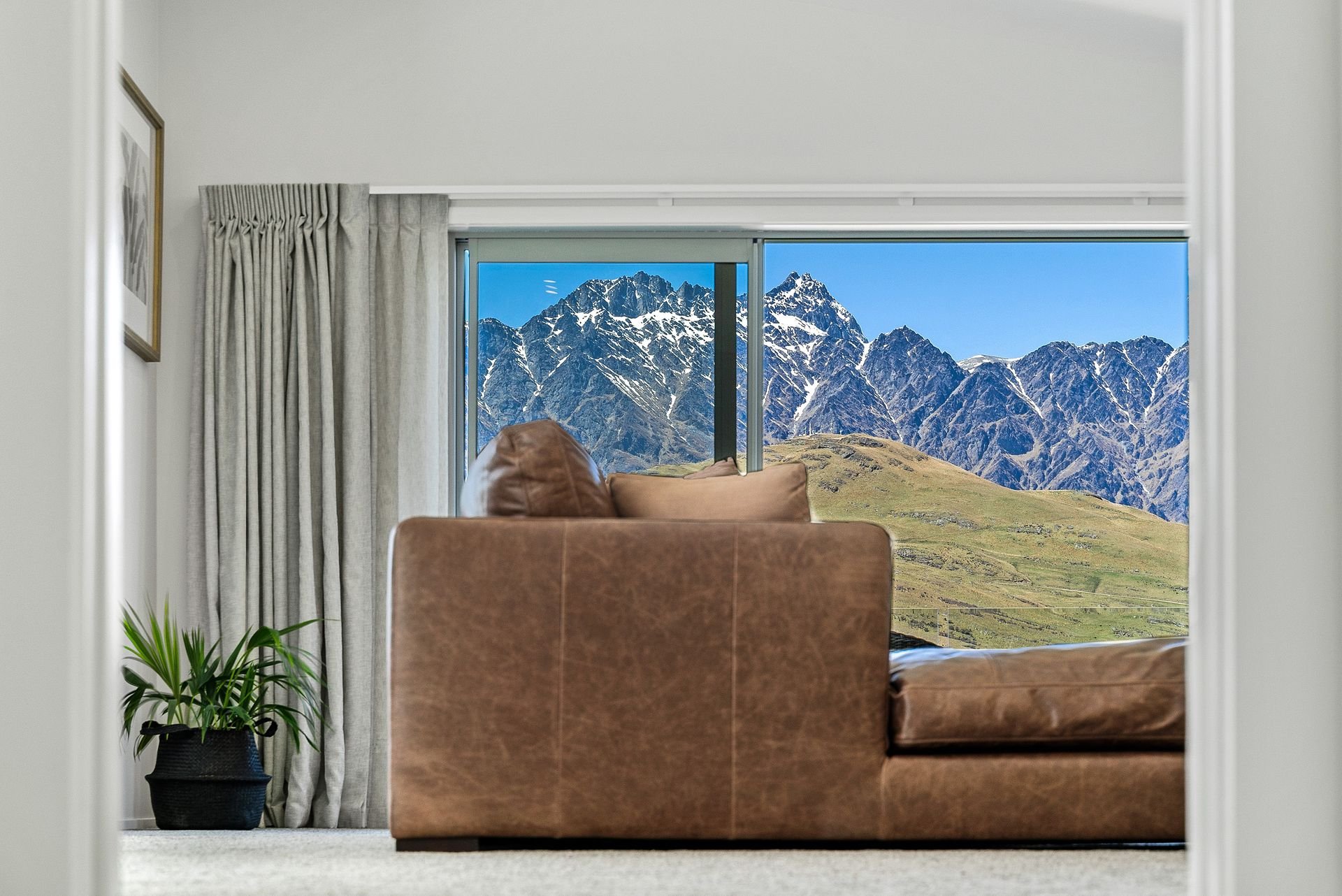 Sofa facing a window framing the Remarkables at Highview Haven, Queenstown