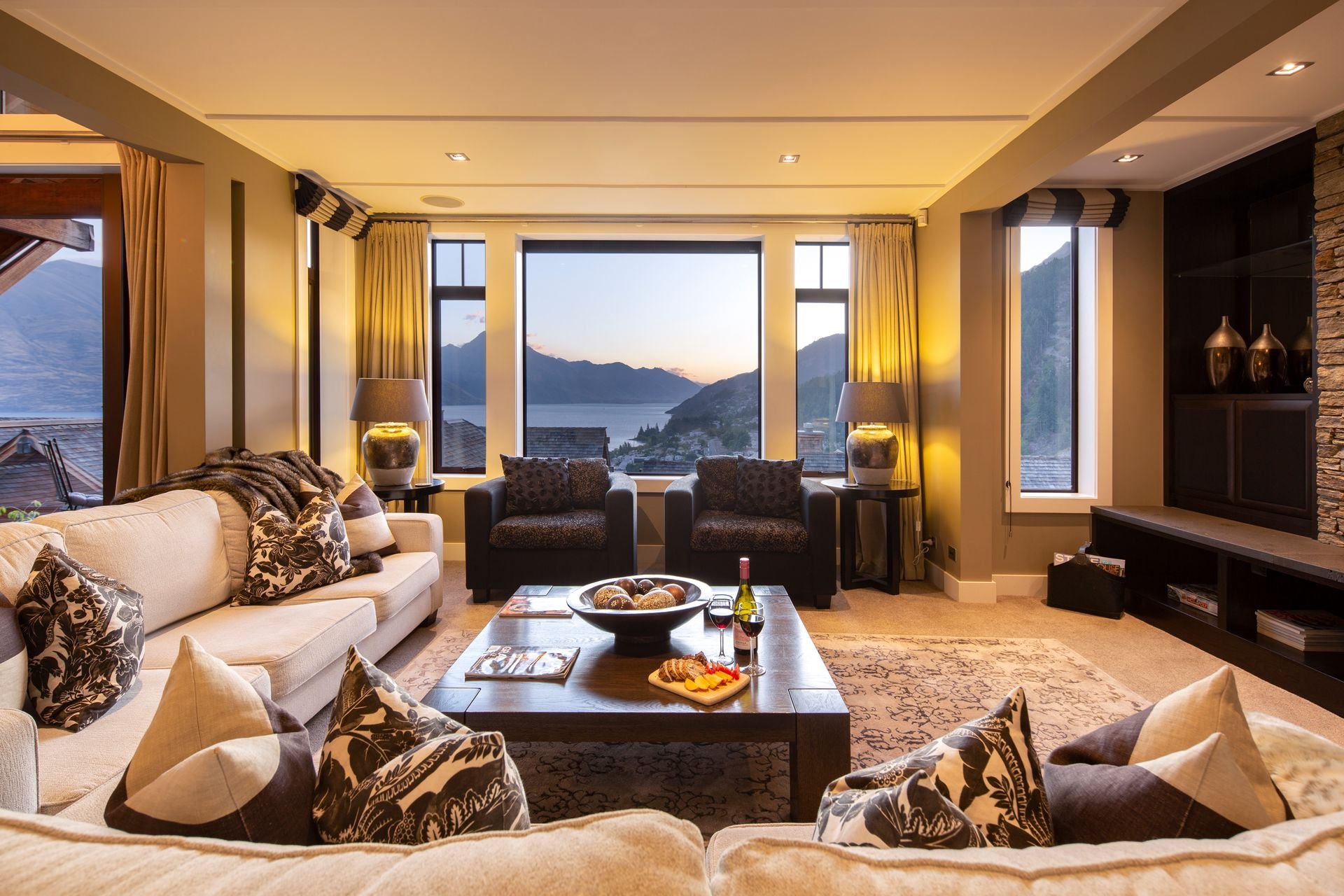 Living room with large windows and lake views at Karamata, Queenstown