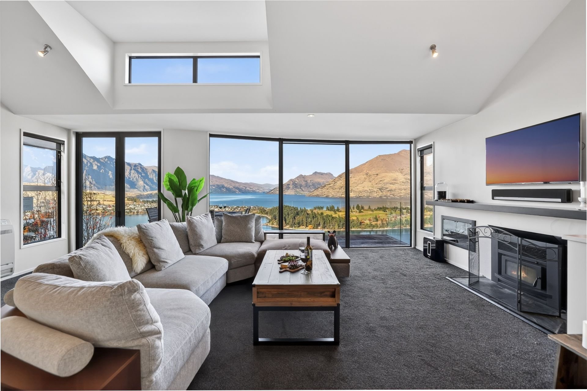 Living room with log burner and lake views at Edinburgh Heights, Queenstown