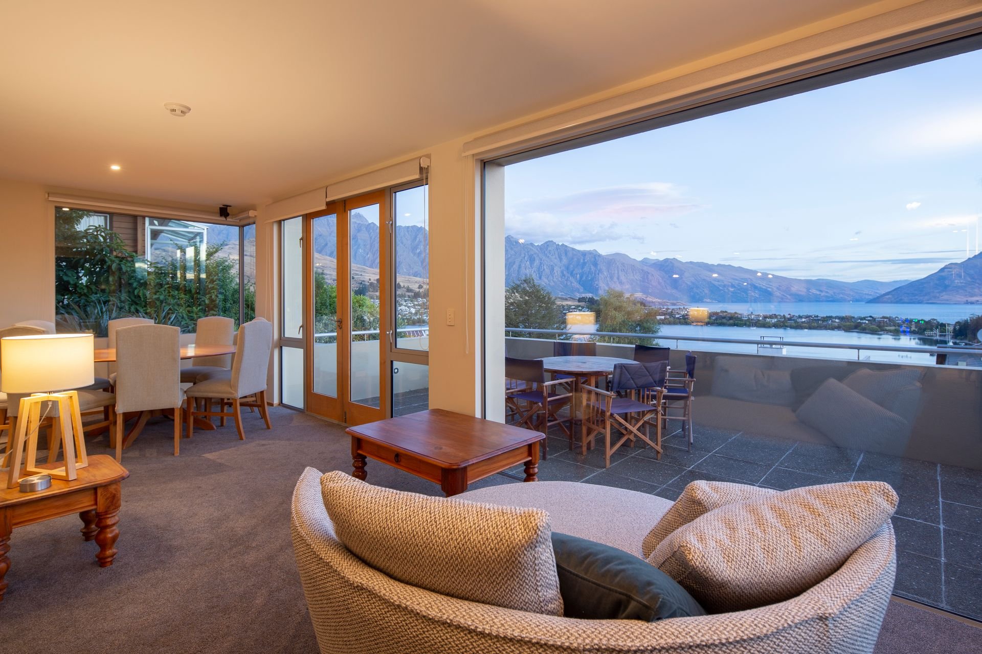 Lounge opening onto the balcony with lake views at Baraka Lake Views, Queenstown