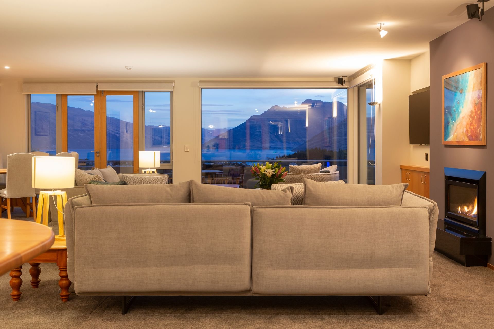 Sofa and fireplace in the living room at Baraka Lake Views, Queenstown