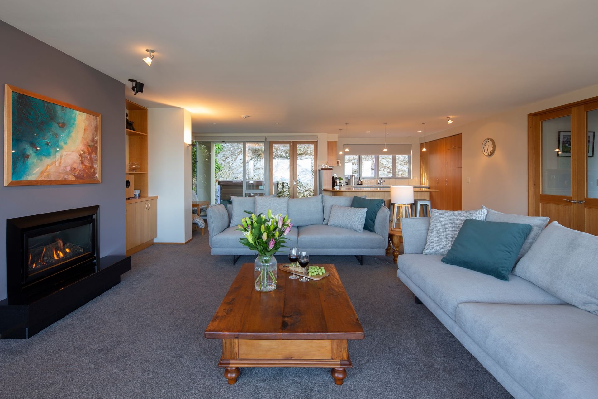 Living room with fireplace and sofas at Baraka Lake Views, Queenstown