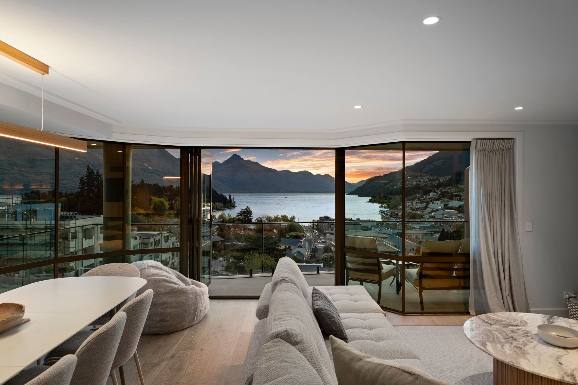 Living and dining area with lake views at dusk at Sunset Views, Queenstown