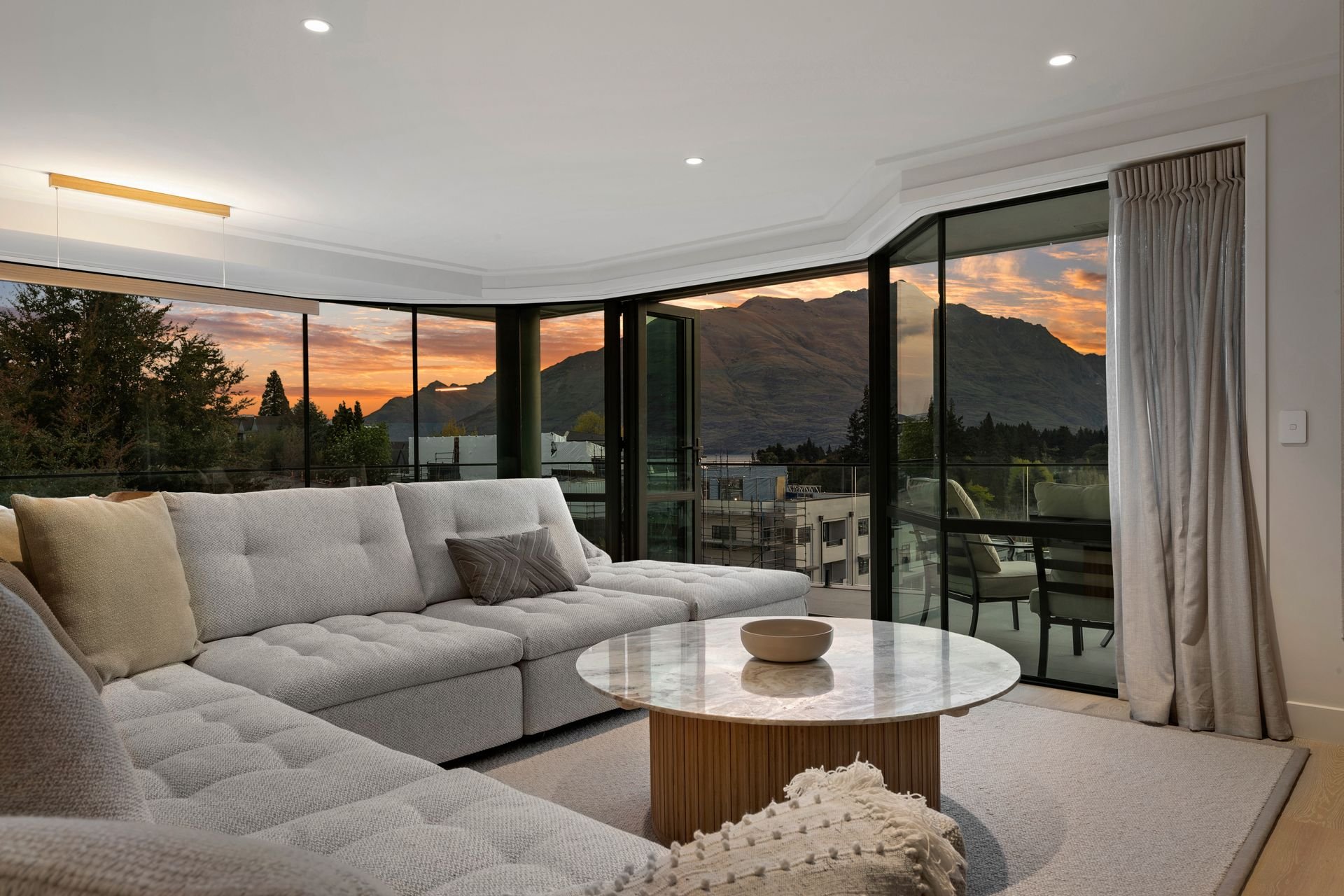 Lounge with curved windows and lake views at Sunset Views, Queenstown