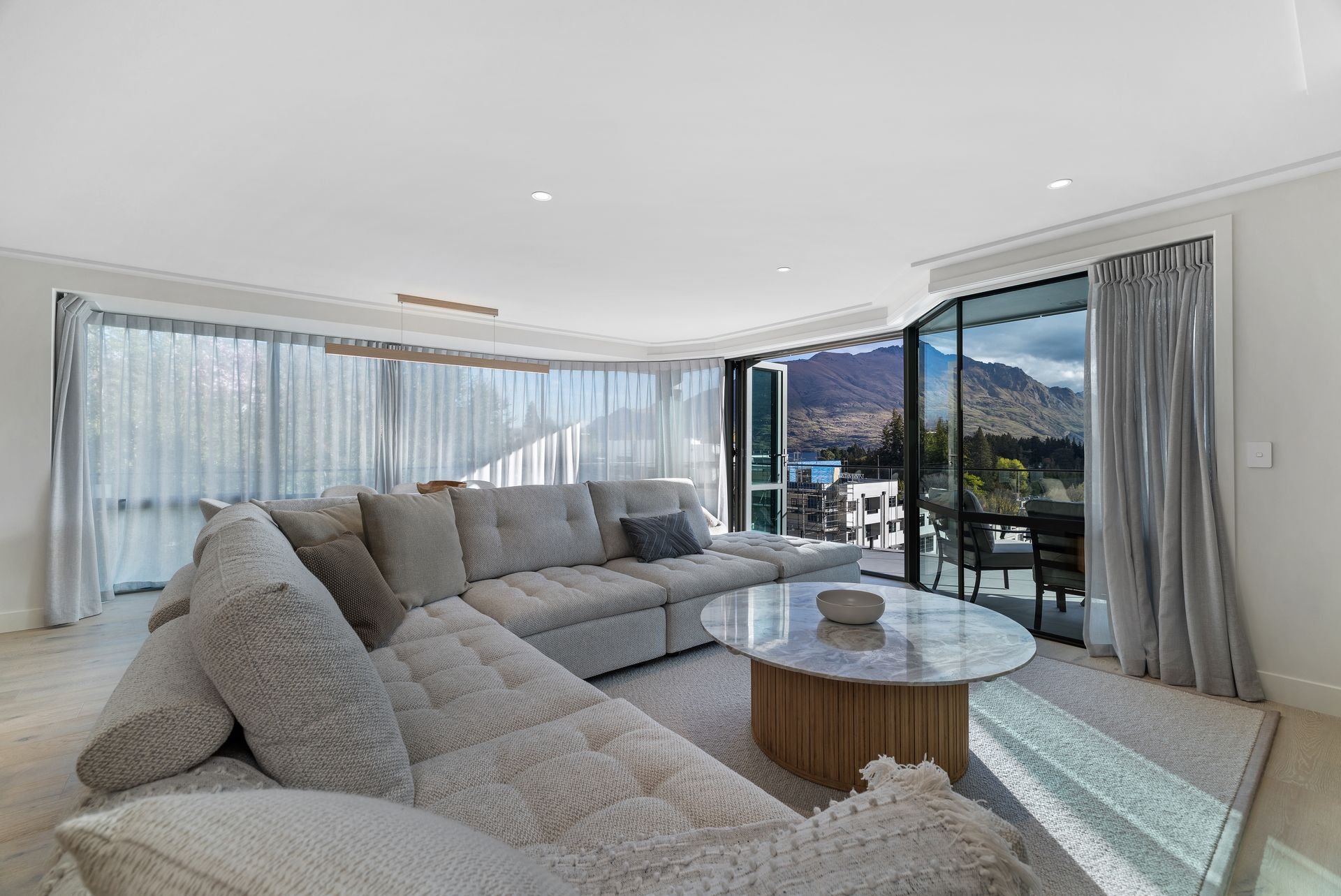 Lounge with sofa and balcony doors at Sunset Views, Queenstown
