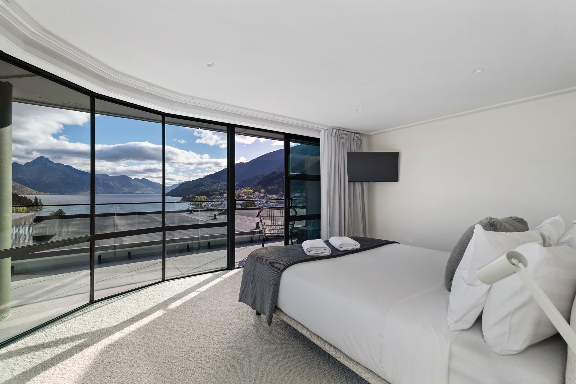 Bedroom with floor-to-ceiling windows and lake views at Sunset Views, Queenstown