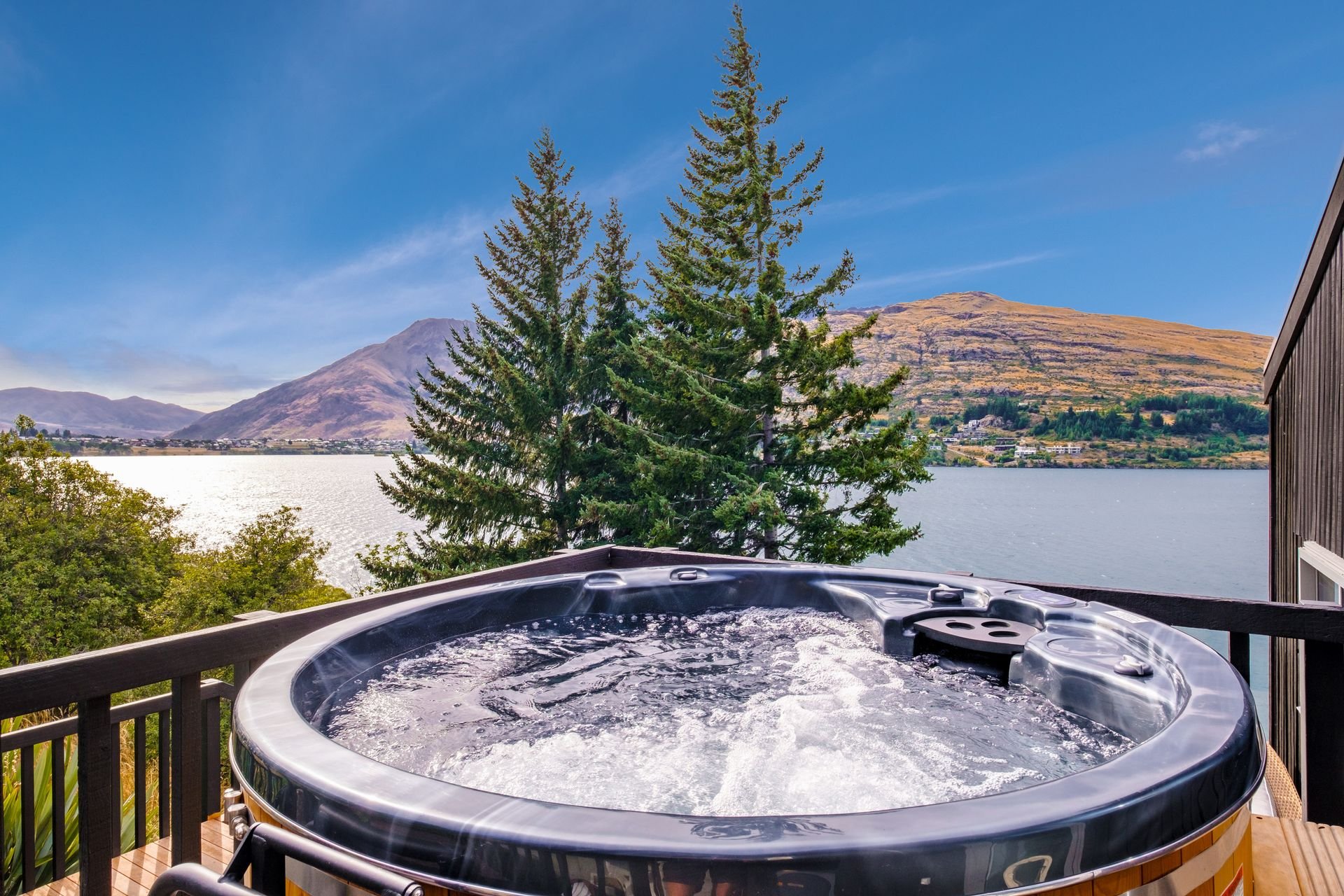 Spa pool on the deck with lake views at Queenstown Lakefront Dream, Queenstown