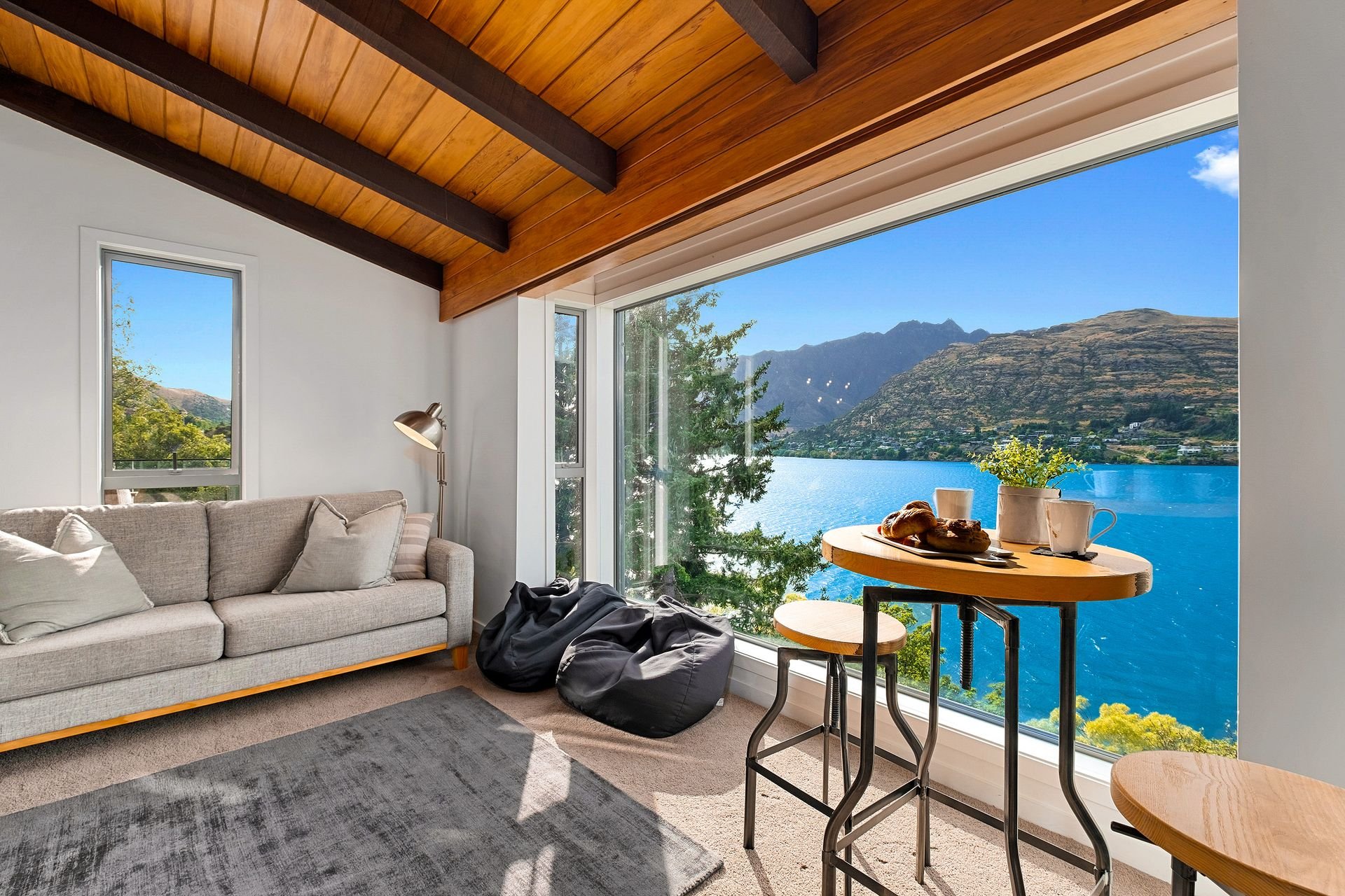 Living room opening onto the deck with lake views at Queenstown Lakefront Dream, Queenstown